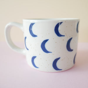 Speckled white ceramic mug with  hand painted blue crescent moons 